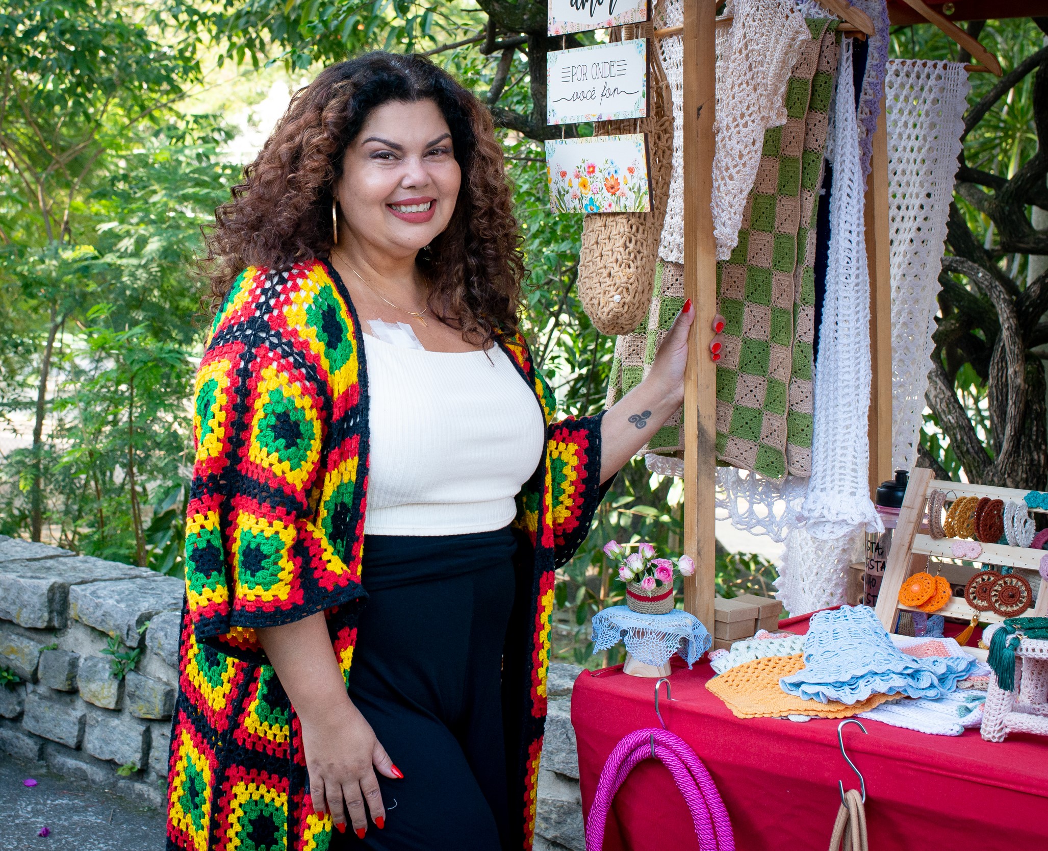 Mulher com roupas coloridas, feira de artesanato ao ar livre.