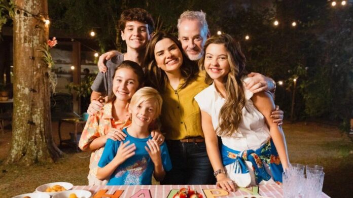 Família feliz reunida ao ar livre, festa à noite.