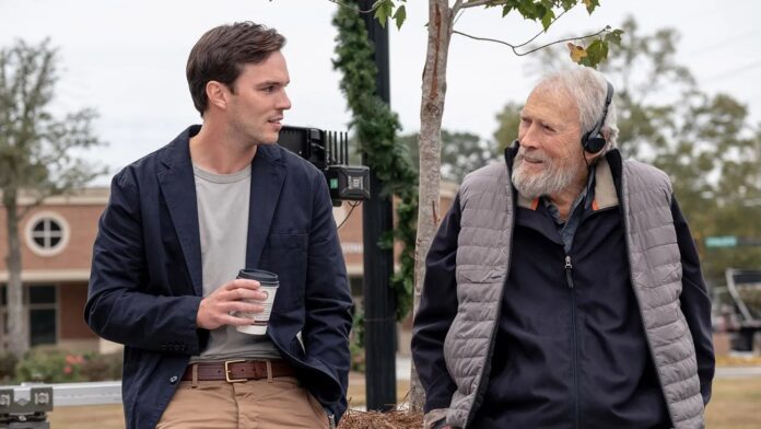 Dois homens conversando em um parque, um com fone.