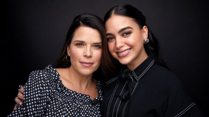 Duas mulheres sorrindo em fundo preto