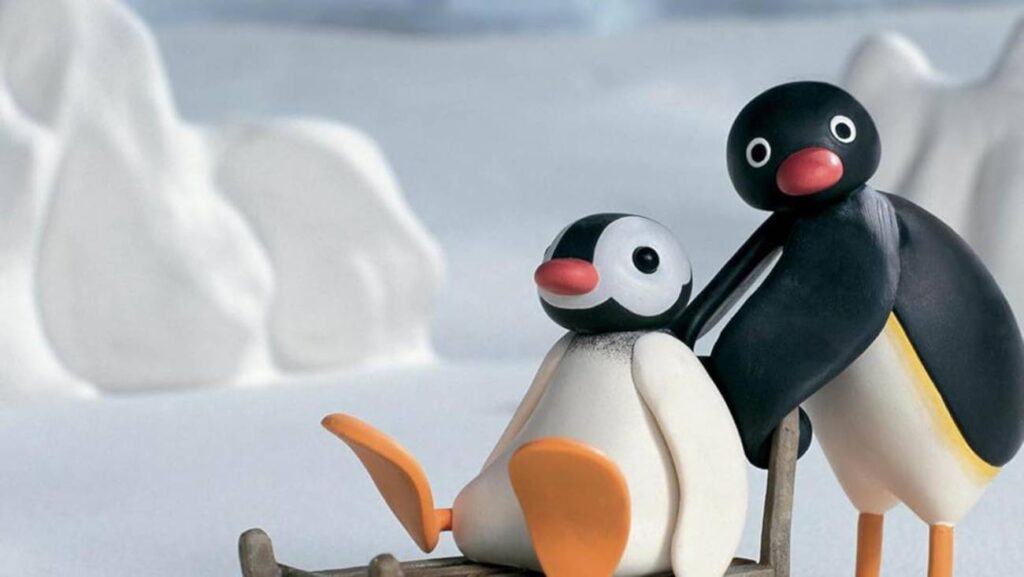 Pinguins animados em trenó na neve.