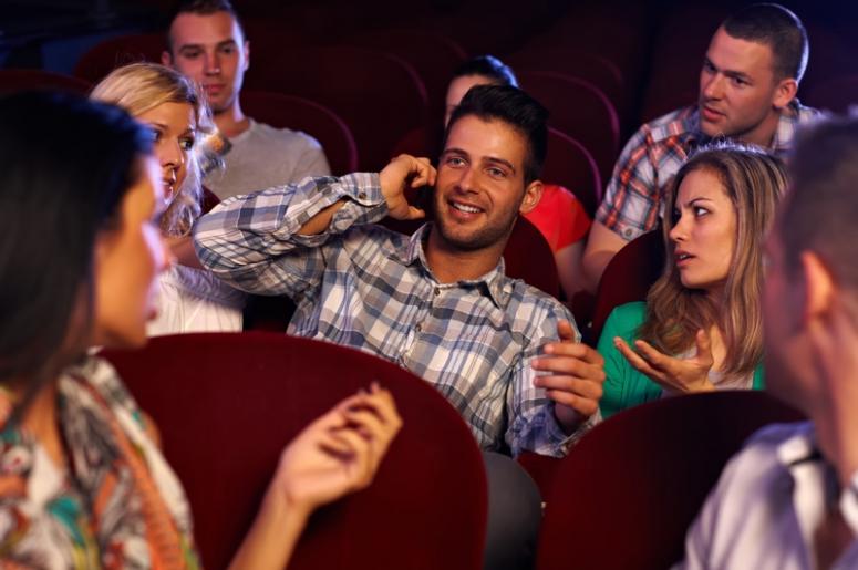 Pessoas assistindo filme e conversando no cinema