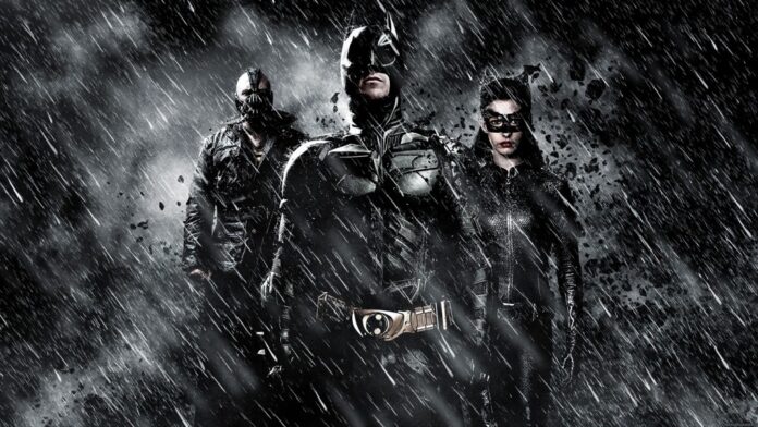 Batman, Batgirl e Bane sob chuva intensa e escombros