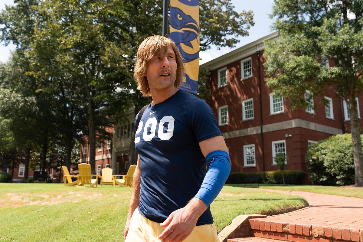 Homem atleta em campus universitário com camisa azul