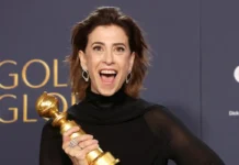 Atriz sorridente segurando troféu em premiação