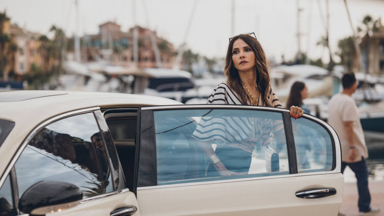 Mulher elegante ao lado de carro em marina